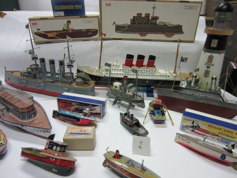 Lot de bateaux jouets en tôle fabriqués vers 1980 dont: - 2 modèles (paquebot et cuirassier) en tôle peinte et méc