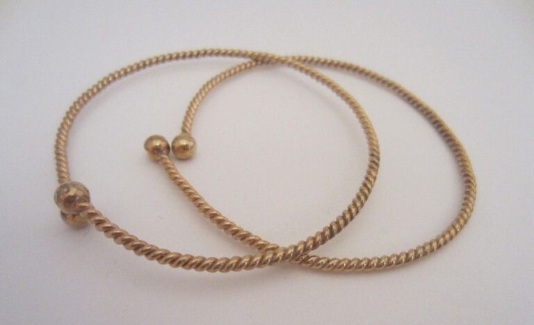 Lot de deux bracelets joncs ouverts torsadés en or jaune (750 millièmes)terminés par un motif boul