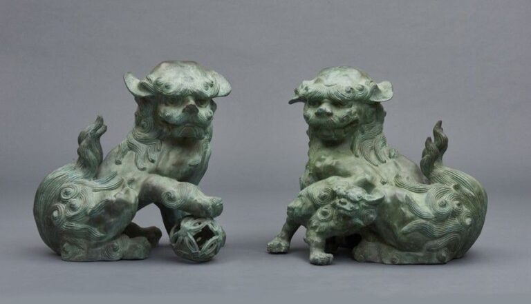 Lot de deux figurines de bronze vert figurant des lions shish