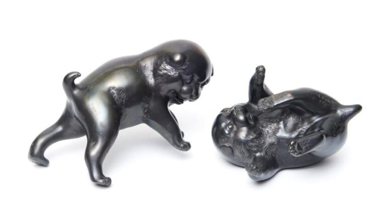 Lot de deux figurines en bronze de couleur foncée représentant deux chiots en train de jouer ensembl