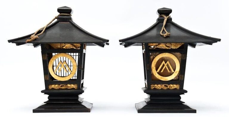 Lot de deux lanternes, en bois laquè noire, garnies d'un emblème familial dorè (mon