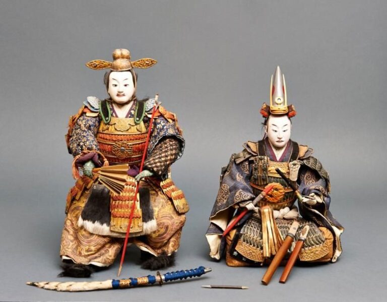 Lot de deux poupées japonaises (ningyo): les deux personnages ont tous deux une expression sérieuse sur le visage et sont vêtus d'une armure yoro