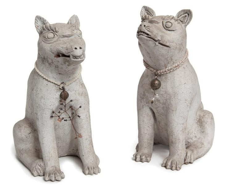 Lot de deux renards (kitsune) en argile de couleur blanc-cassé et portant des porte-bonheurs autour du co