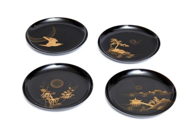 Lot de quatre assiettes laquées noires délicatement garnies de laque en relief maki-e argentée et dorée figurant divers motifs de la natur
