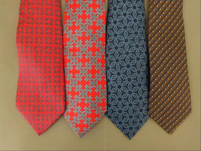 Lot de quatre cravates en soie, deux dans les tons rouge, deux dans les tons bleu, à décor de motifs géométriques variés, dont chaînes