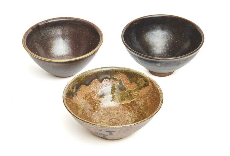 Lot de trois bols à thé en grès pour poudre de thé (chawan): un bol de style tenmoku avec marque au-dessous: Seisen (en forme de courge); une reproduction de bol tenmoku avec un bord en laiton ; et un bol à glaçure verte-marron, avec une date teib? (1987