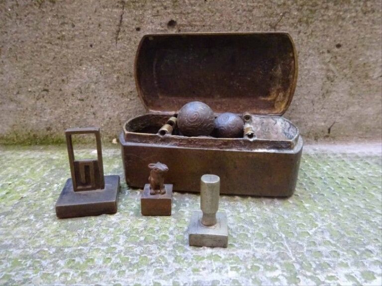 LOT DE TROIS PETITS SCEAUX EN METAL Chine, Epoque début XXe siècle H (le plus grand): 4,6 cm On y joint,, dans une boîte, un lot de onze "billes" en métal, probablement des poids à opiu