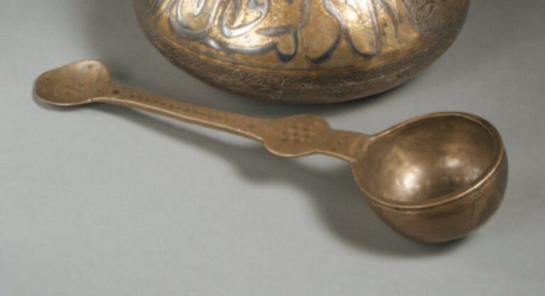 LOUCHE AUX CERCLES Cuilleron hémisphérique à manche plat terminé par un petit cuilleron ovoïde, en bronze blanc, gravé de cercle