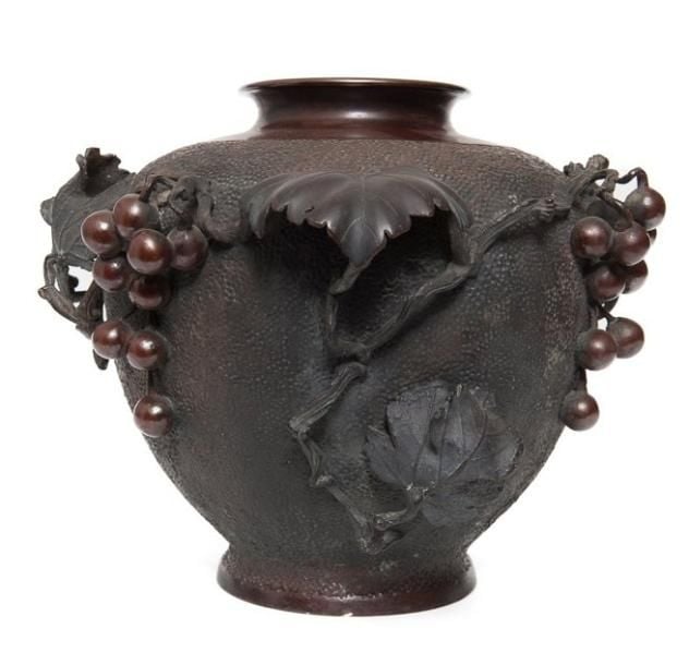 Lourd vase en bronze de couleur marron foncé, avec un décor en relief de feuilles de vignes et de raisin