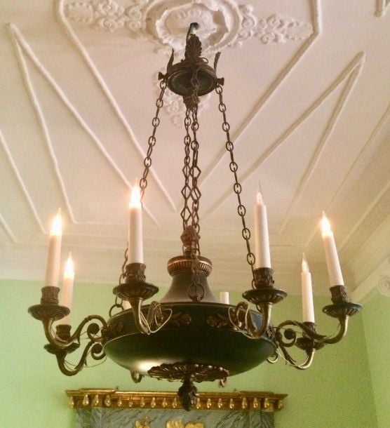 Lustre circulaire en tôle laquée vert et bronze, forme balustre et supportant huit bras de lumière en corn