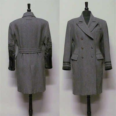 MANTEAU croisé 9/10 en lainage anthracite, col cranté sur double boutonnage, manches longues appliquées de soutâches, galons et velours noirs, poche poitrine, deux poches à rabat, martingale et fente au dos (griffe noire, graphisme vert) (env TM/L) (petite usure aux emmanchures sur velours)