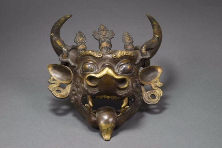MASQUE DU DHARMAPALA YAMANTAKA EN BRONZE A DEUX PATINES  Tibet, Epoque fin du XIXe siècle Fonte lourde ayant requis trois moules : un pour le masque, deux pour les serpent