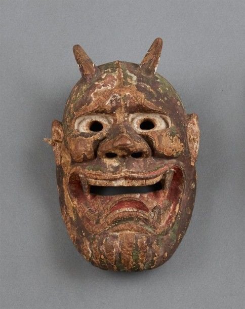 Masque en bois figurant le visage d'un démon on