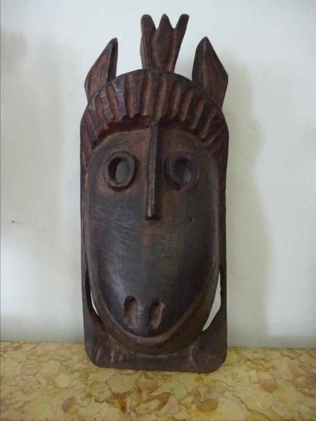 MASQUE INDIEN PROGNATHE AUX DEUX OREILLES EN BOIS SCULPTE Inde de l'Arunachal-Pradesh ou Bhoutan ou Népal Epoque XXe siècle H: 30 cm - l: 14 cm - P: 9 cm (restauration une partie recollée) Présenté sur un socle moderne A CARVED WOODEN PROGNATHOUS MASK India Arnuachal-Pradesh Bhutan or Nepal 20th century
