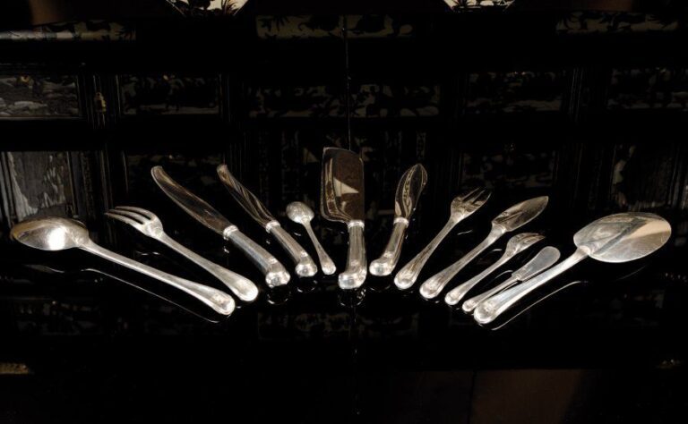 Ménagère en argent de 222 pièces composée de 36 fourchettes, 36 couteaux et 12 cuillers de table ; 18 couverts à poisson ; 12 couverts et 24 couteaux à entremets, 12 fourchettes à gâteau, 11 cuillers à café, 17 couteaux à beurre et 14 pièces de service ; modèle à manche concave armorié ; les fourchettes à 3 dents, les cuillerons à queue-de-rat Par Puiforcat, poinçon Minerve Poids hors couteaux : 11 484 g