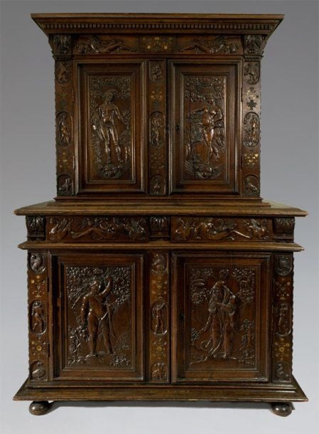 Meuble à deux corps, en noyer richement sculpté à décor incrusté de nacre et d'étain, présentant des vases fleuris et feuillagé