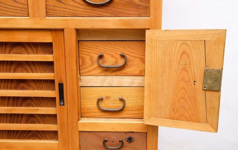 Meuble en bois simple, comprenant, en haut des portes coulissantes, trois petits tiroirs, des portes coulissantes, deux petits tiroirs derrière une porte et un tiroir de la même taill