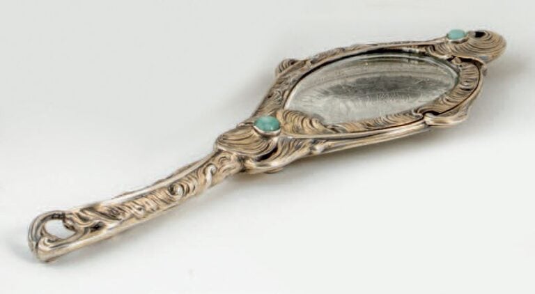 MIROIR À MAIN DOUBLE FACE en vermeil (minimum800‰), décor de plumes de paon stylisées et cabochons de pierre vert
