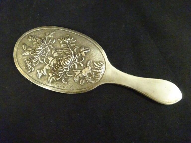 Miroir en argent Chinois d'exportation orné au repoussé d'un décor de pivoines le manche à décor gravé de feuillage