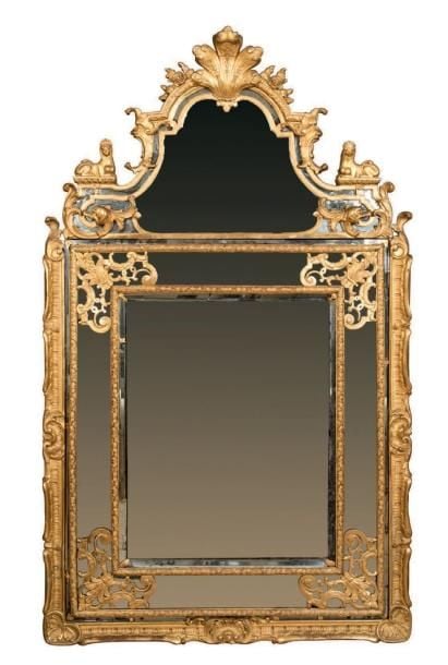 Miroir parcloses à fronton en bois doré à décor d'entrelacs et motifs floraux stylisé