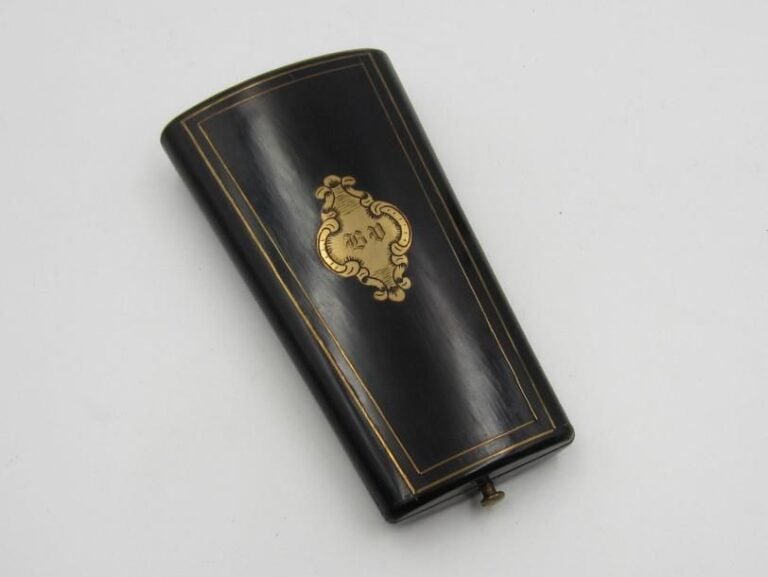 NÉCESSAIRE À COUTURE «trapèze» composé d'un écrin en ébène ouvrant à charnières rehaussé d'un monogramme, et de trois éléments à l'intérieur en vermeil (mi
