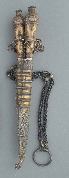 NÉCESSAIRE D'ARTISAN Composé de trois outils à poignée filigranée munie de chaînettes et de pendeloques en forme de croissants, dans un fourreau ciselé et gravé dont l'extrémité est en forme de tête de drago