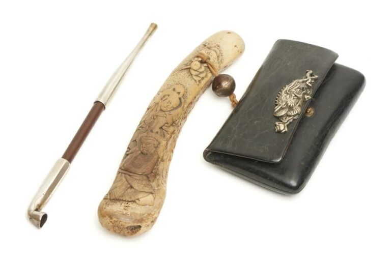 Nécessaire de fumeur (tabako’ire) comprenant un étui en cuir garni d’un ornement en argent figurant un dragon à perle (kabuse); un ojime en métal