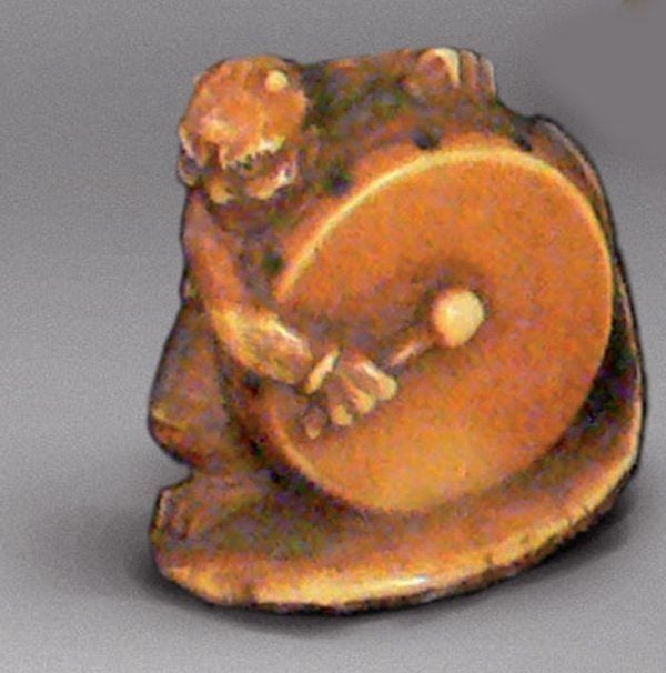 Netsuke en ivoire patiné, représentant Raden, le dieu du Tonnerre, dans les nuages, frappant sur son tambou