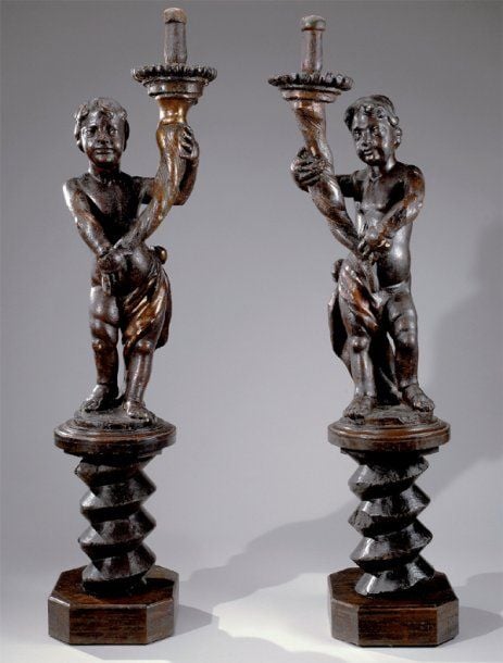 Paire d'amours formant piques cierge, en bois sculpté anciennement dor
