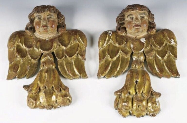 Paire d'angelots en noyer sculpté, doré ou polychrome; les ailes déployées, ils s'appuient sur des culots à feuilles d'acanthe et fruit