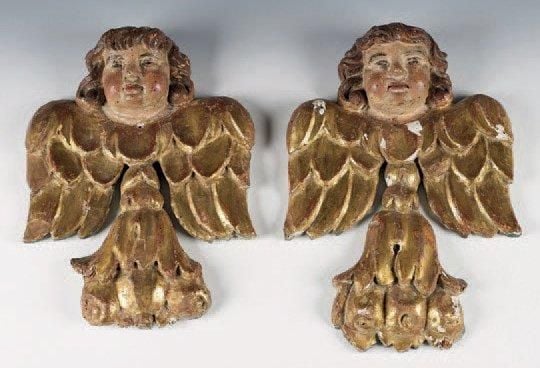 Paire d'angelots en noyer sculpté, doré ou polychrome; les ailes déployées, ils s'appuient sur des culots à feuilles d'acanthe et fruit