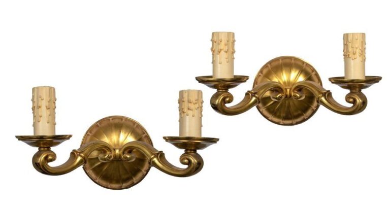 Paire d'appliques à deux lumières en bronze doré; les extrémités à enroulements; sur un disque à larges nervure
