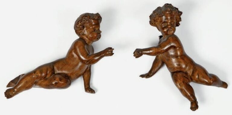 Paire d'enfants en noyer sculpté représentés nus dans des attitudes animée