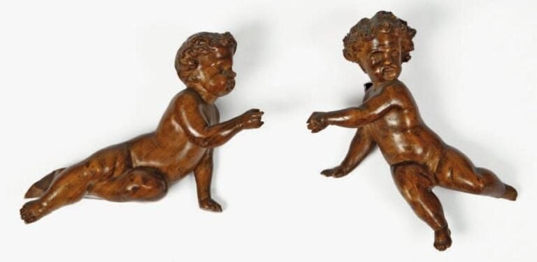 Paire d'enfants en noyer sculpté représentés nus dans des attitudes animée