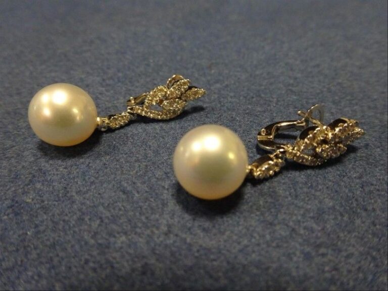 Paire de BOUCLES D'OREILLES à pendants ornés de perles de culture (perles des mers du sud, surmonté de branchages pavé de diamant