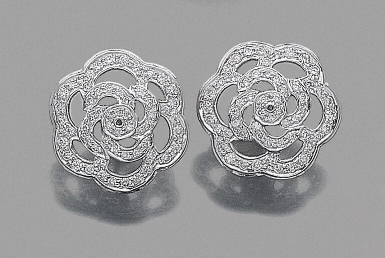 •Paire de BOUCLES d'OREILLES «camélias» en or gris (750‰) ajouré serti de diamants taille brillan