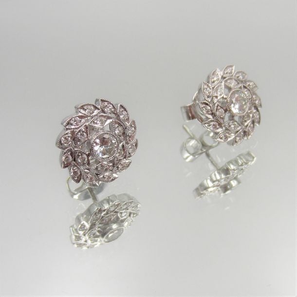 Paire de BOUCLES d'OREILLES circulaires «couronne de feuilles» en or gris (750 millièmes) ajouré, serti de diamants taille brillan