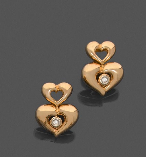 •Paire de BOUCLES d'OREILLES «cœurs» en or jaune (750‰) bombé et ajouré, sertie d'un diamant taille brillan