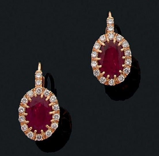 PAIRE DE BOUCLES D'OREILLES en jaune (750 millièmes) serti d'un rubis de forme ovale entouré de diamants taille brillan
