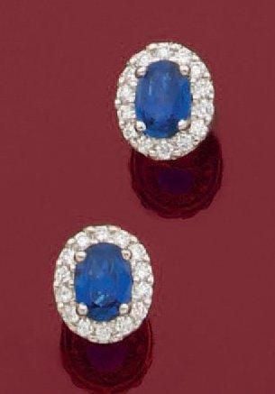 PAIRE de BOUCLES D'OREILLES en or gris (750 millièmes) serti d'un saphir ovale entouré de diamants taille brillan