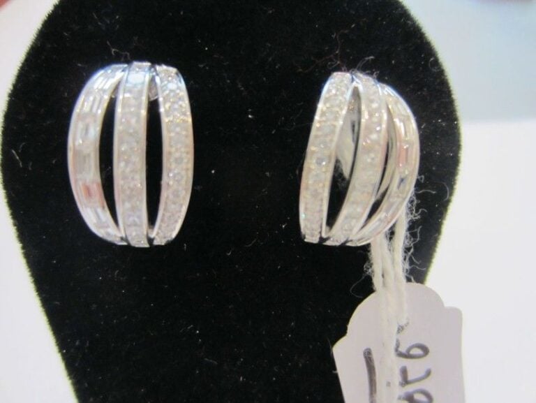 PAIRE DE BOUCLES D'OREILLES en or gris bombé et ajouré serti de trois lignes de diamants taille brillant, princesse et baguett
