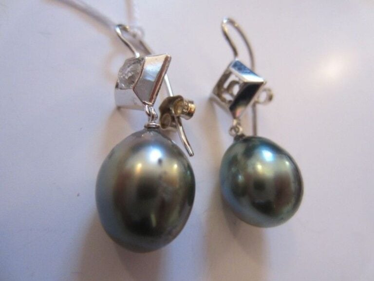 Paire DE BOUCLES D'OREILLES en or gris retenant une perle de culture grise de Tahiti piriforme surmonté d'un motif losangique serti d'un diamant taille brillan