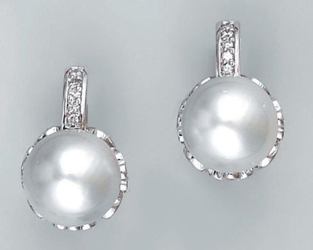 Paire de BOUCLES D'OREILLES en or gris serti d'une perle de culture blanche et de diamants taille brillant, à motifs de fleurettes sur le côt