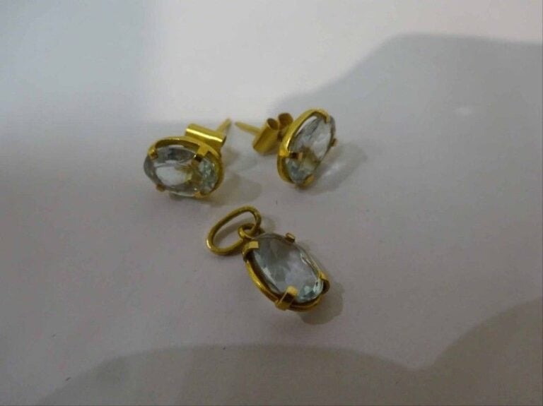 Paire de boucles d'oreilles en or jaune 18K (750°/00) serties d'aigue-marine ovale, et son pendentif assort