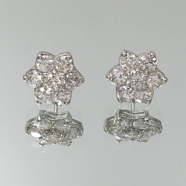 Paire de BOUCLES D'OREILLES «fleur» en or gris (750 millièmes) serti de sept diamants de taille brillan