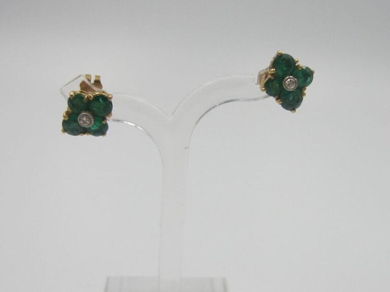 PAIRE de BOUCLES D'OREILLES «fleurettes» en or jaune (750 millièmes) serti d'un diamant entourée de quatre émeraude