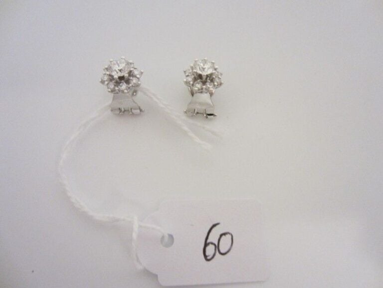 PAIRE DE BOUCLES D'OREILLES «fleurs» en or gris (750 millièmes) serti de diamants taille brillant, dont un au centre plus importan