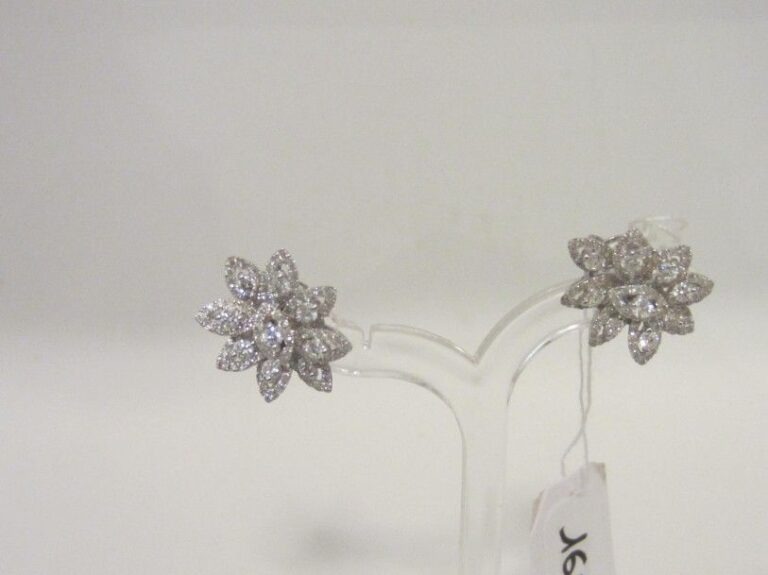 PAIRE DE BOUCLES D'OREILLES «fleurs stylisées» en or gris (750 millièmes) ajouré serti de diamants taille brillant dont dix-huit plus important
