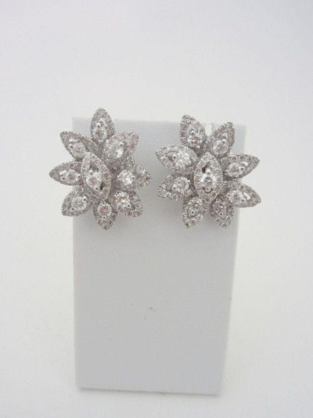 PAIRE DE BOUCLES D'OREILLES «fleurs stylisées» en or gris (750 millièmes) ajouré serti de diamants taille brillant dont dix-huit plus important