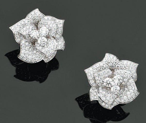 Paire de BOUCLES D'OREILLES «roses» en or gris serti de pavages de diamants et de trois diamants taille brillant au centr